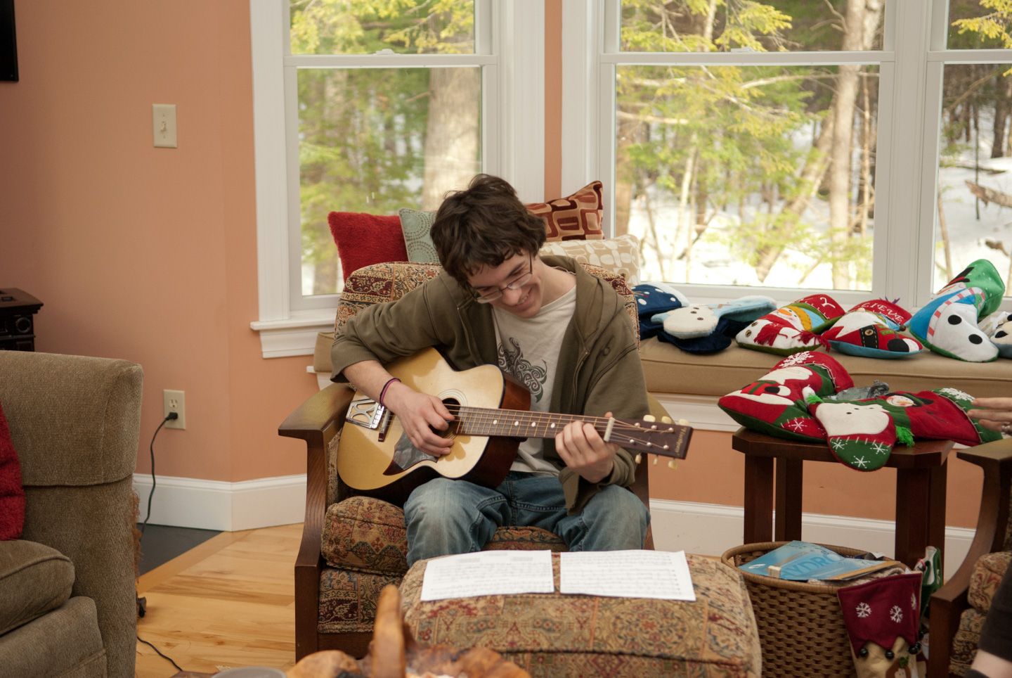 Young man playing the guitar with sheet music in front of him