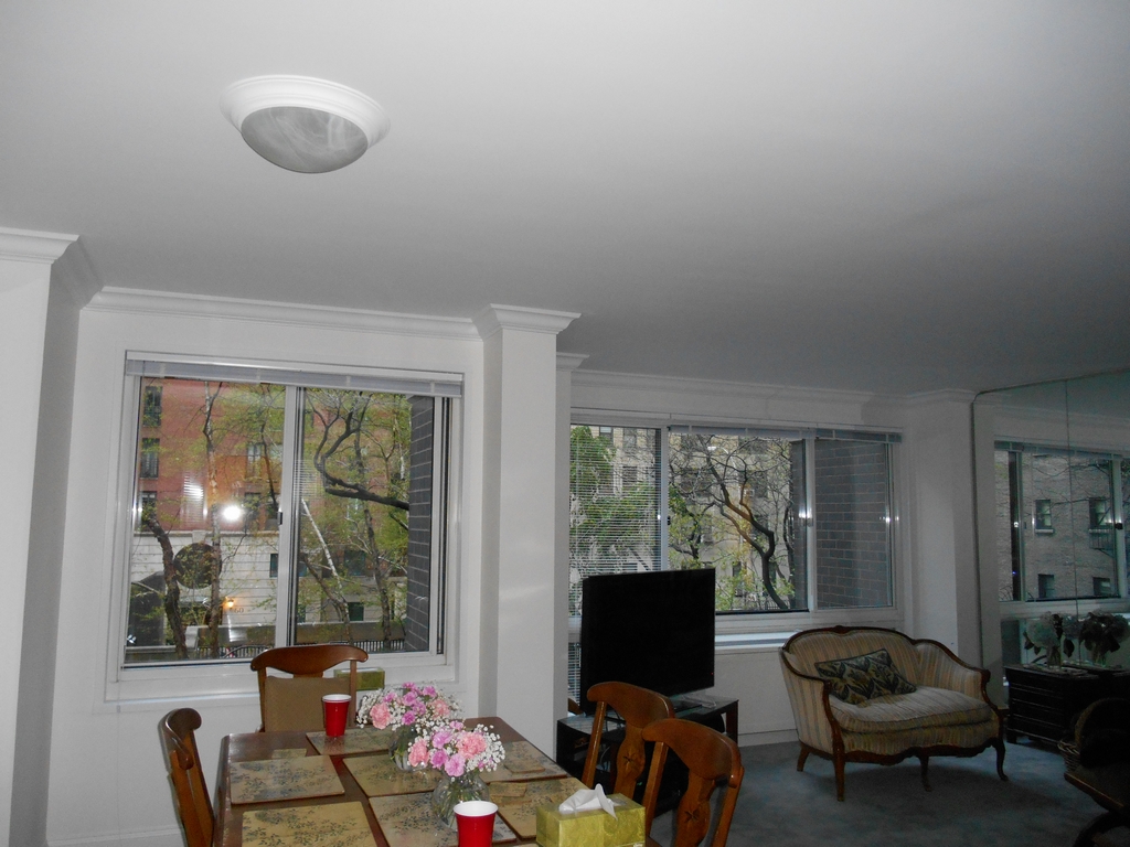 Dining and living area at Diane and Frank's with large windows, a small table, television, and seating area