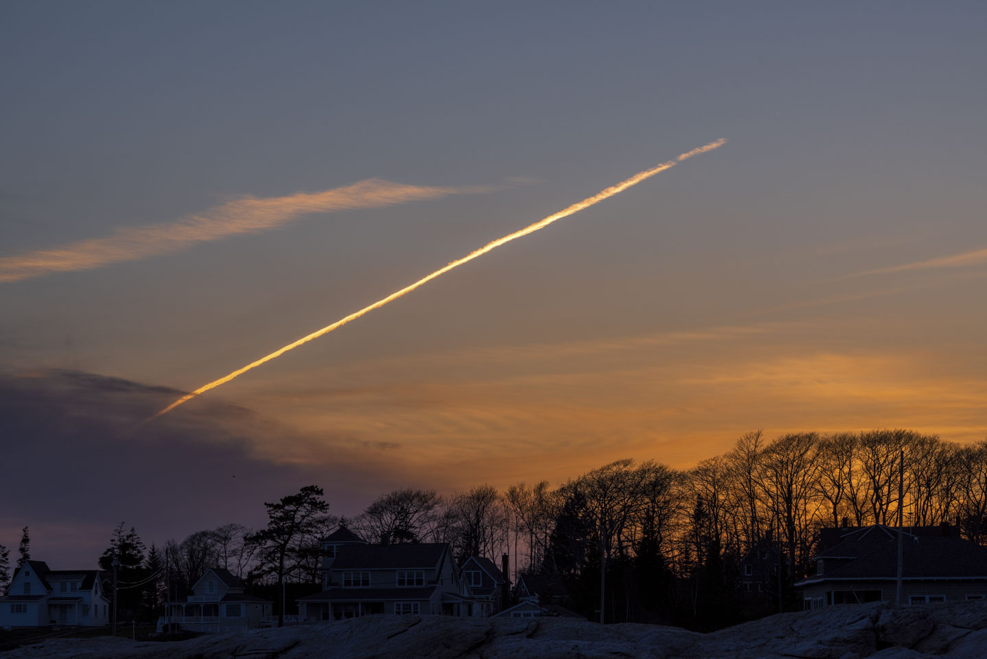 Sunset lighting the contrail from a jet