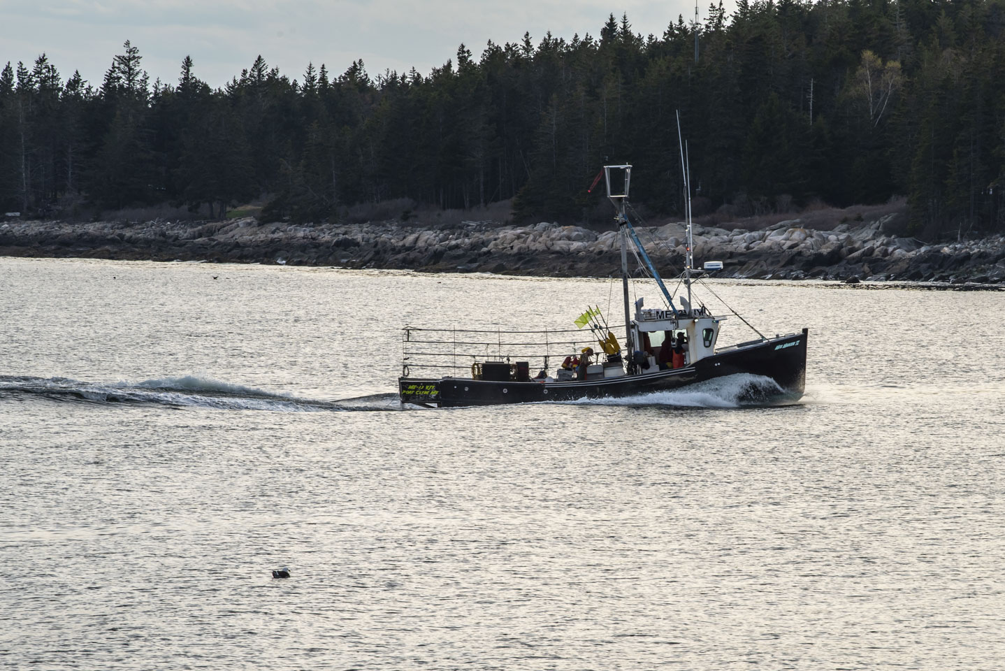 a lobster boat moving through water in Maine