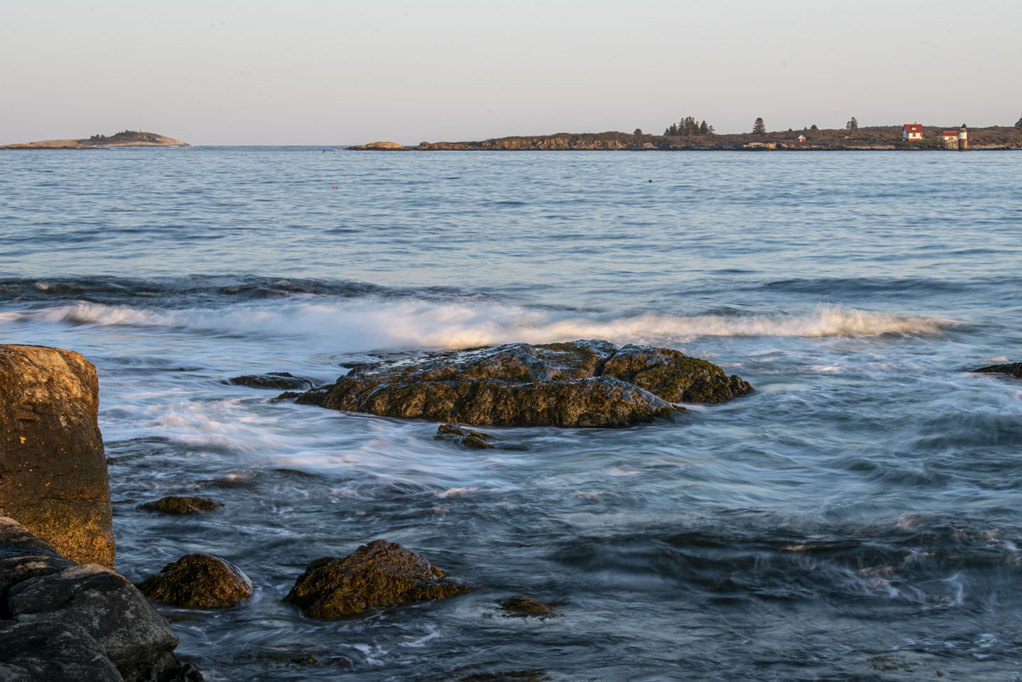 A wave with Ram Island Lighthouse in the background of the photo