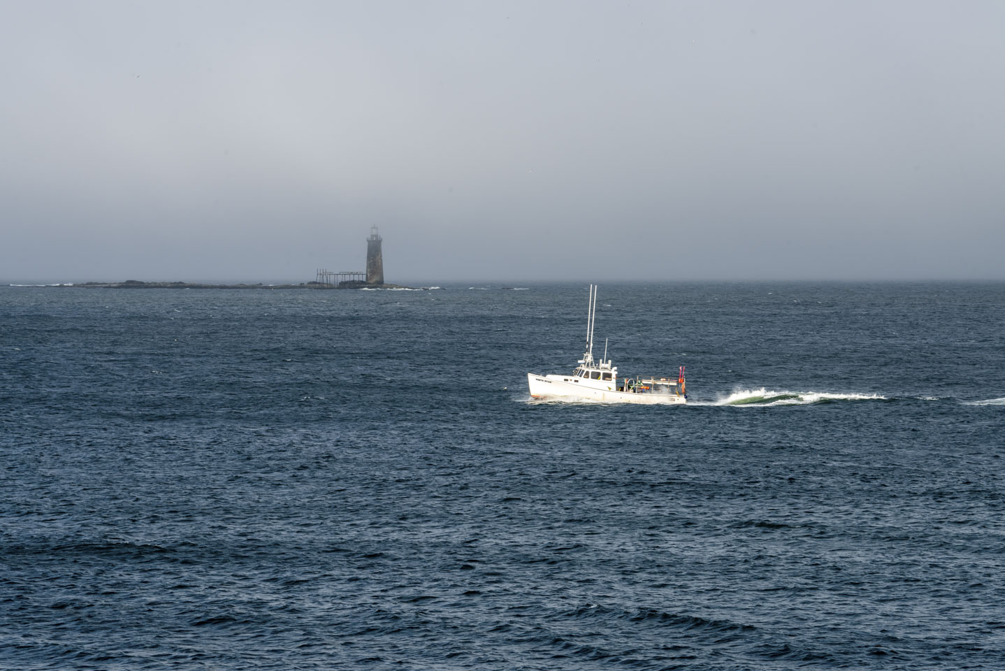 Ram Island Ledge light with a boat in front