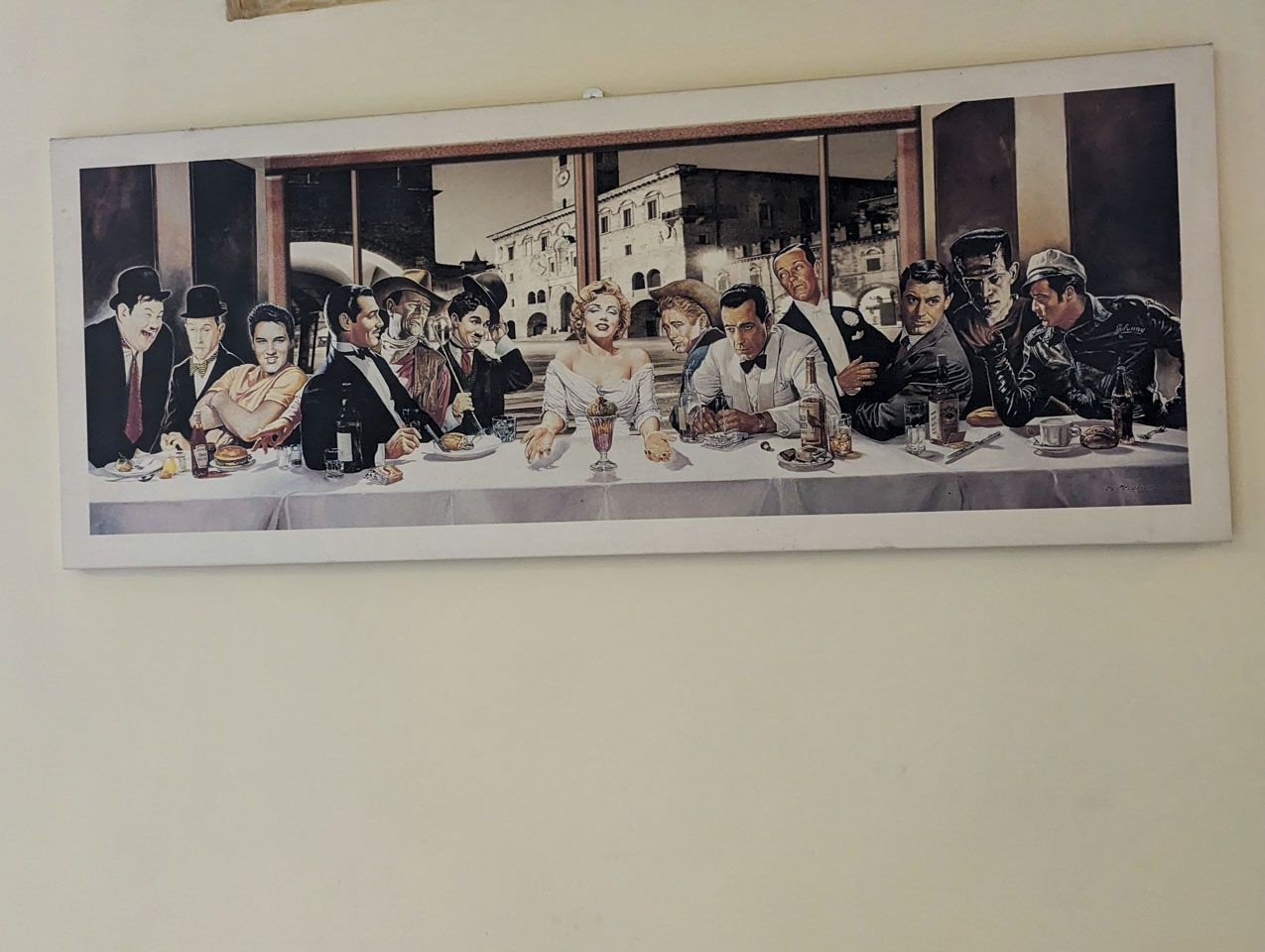 Poster designed to look like The Last Supper, with various Hollywood stars, and a background of the local Italian city