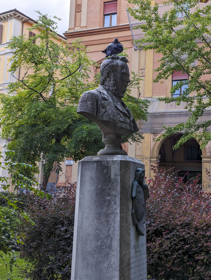 The bust of a man on a pedestal, with a pigeon on top if the head.