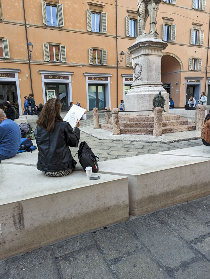 A woman making a drawing of the statue.