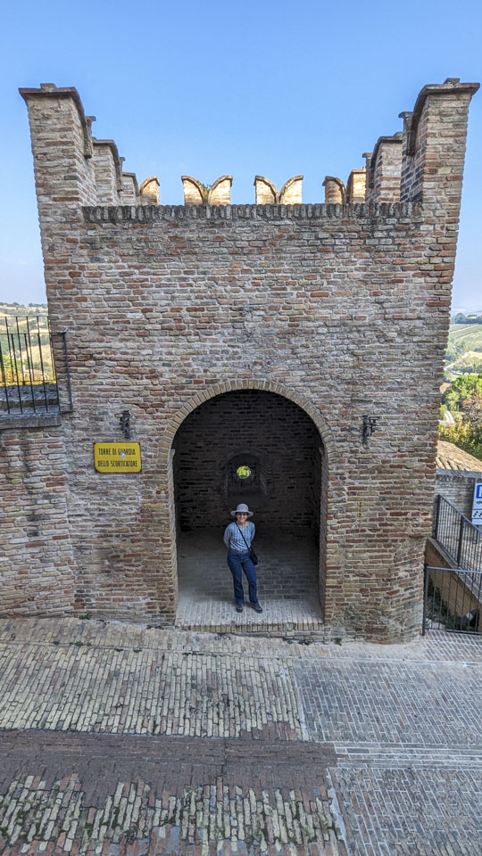 Anne under the arched entry of a small tower