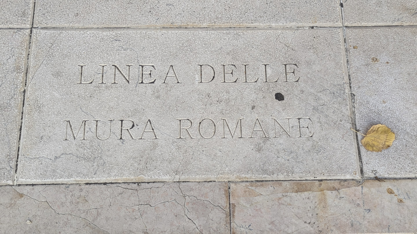 A stone in the road that states this is the former line of the Roman wall.