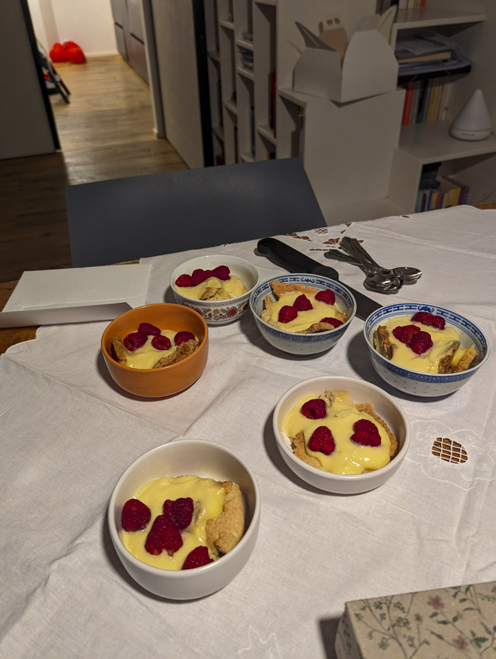 Bowls of a custard and cake dessert on a table with a white table cloth.
