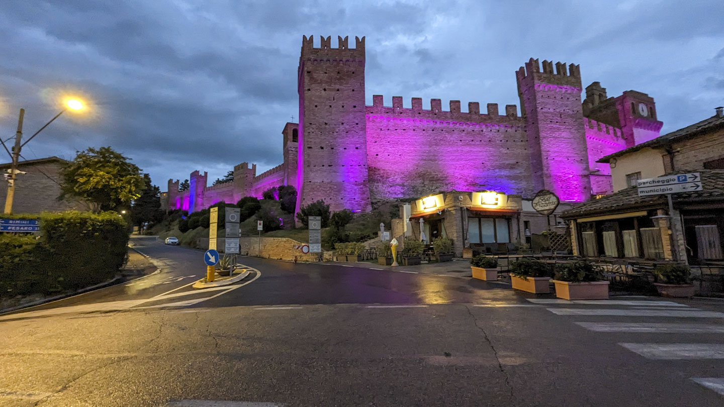 The Gradara Castle with purple light shining on it.
