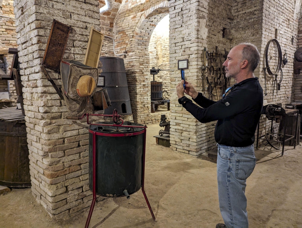 Paul taking a photograph of a metal tank that has some racks inside it and a handle for turning the racks.