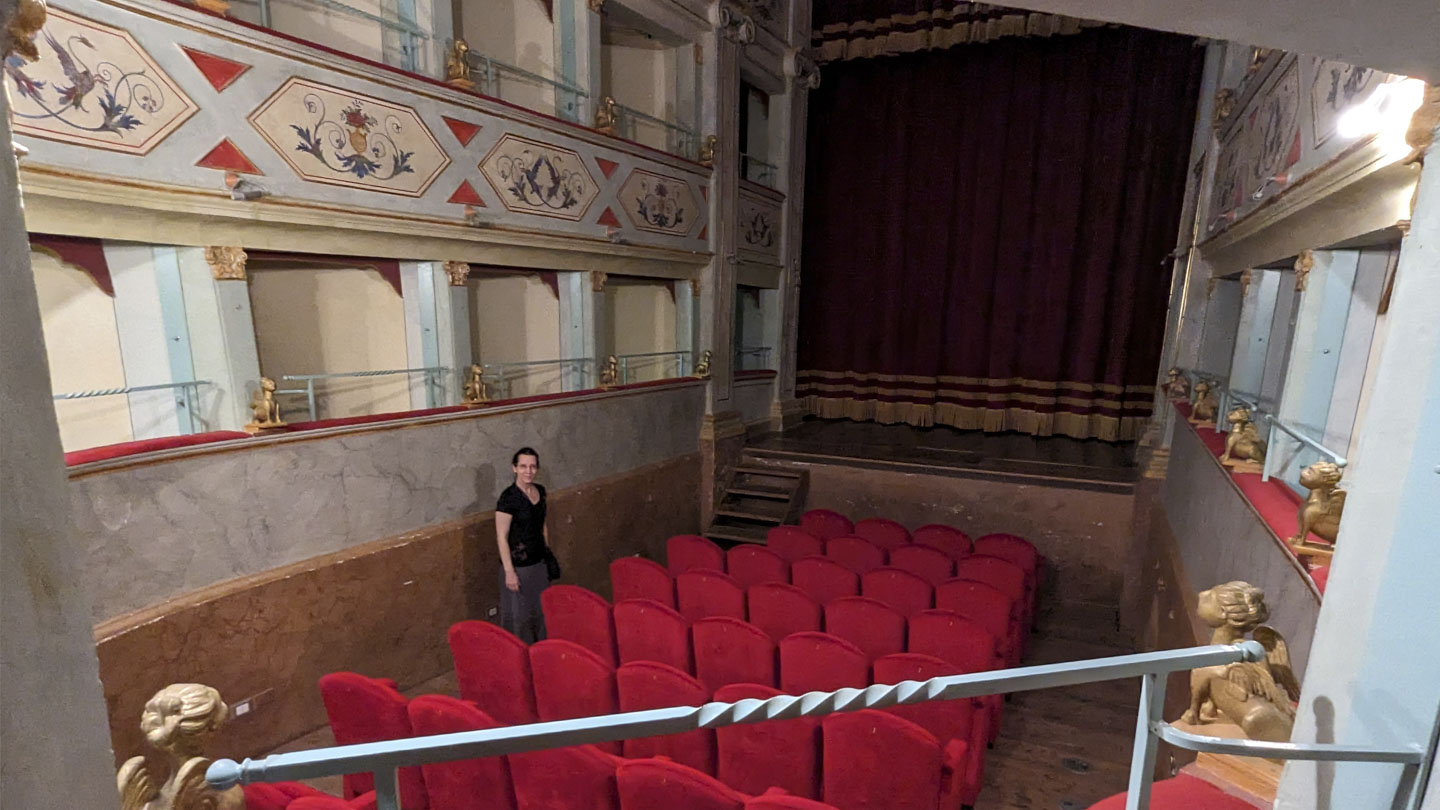 View of Anne standing next to the floor seats, a seen from the 1st balcony