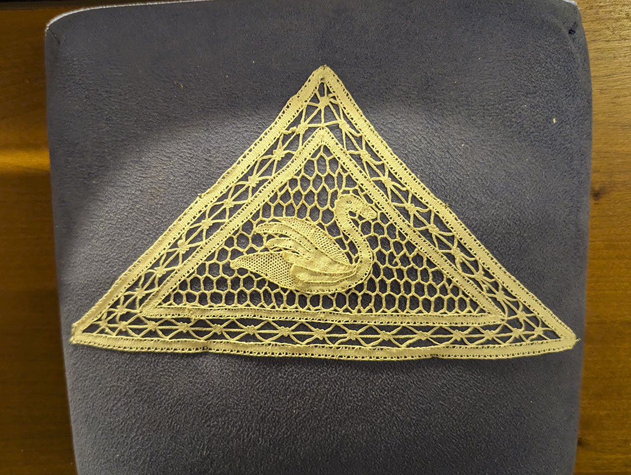 triangular piece of lace with a swan motif