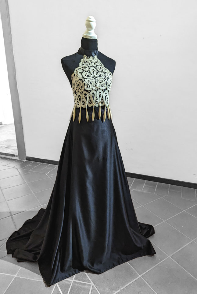 A black sleeveless dress with a bodice of Offida bobbin lace.
