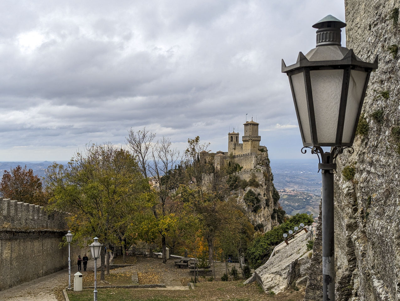 The tower stands at the edge of a cliff face that drops directly off, while the other side slopes off.