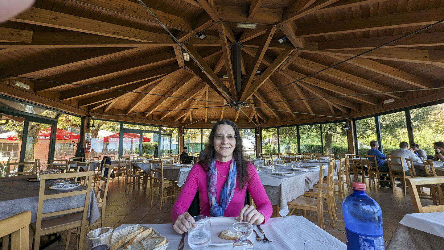 Anne sitting at a restaurant table, with some bread in front of her.