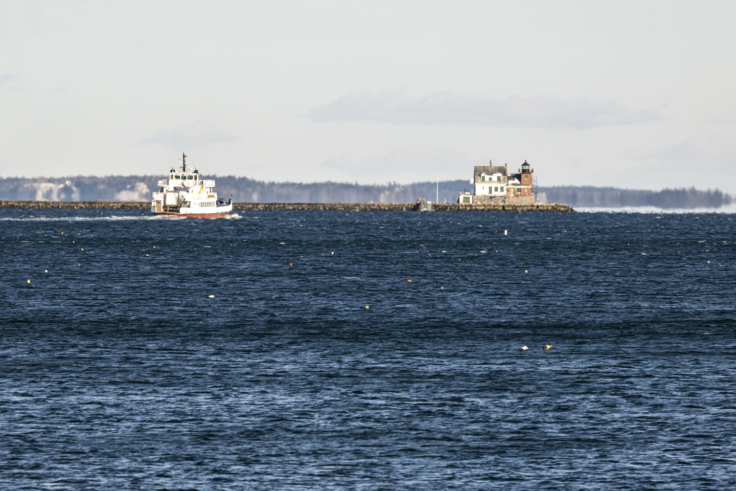 A boat is approaching the Rockland Breakwater Lighthouse.