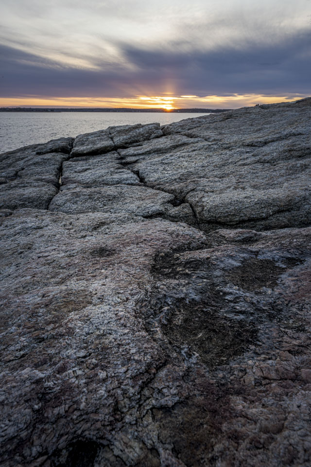 A view over rocks towards the setting sun.