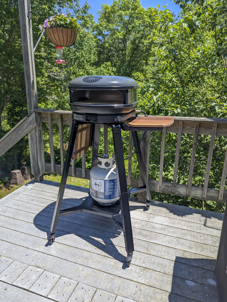 The Gozney pizza oven outside on a deck.