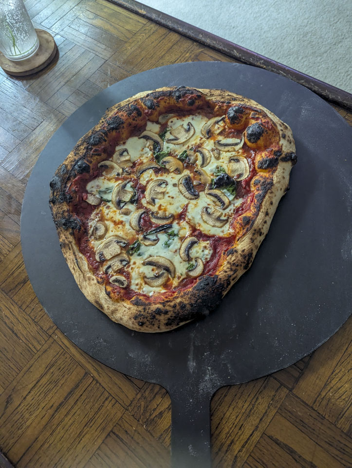 Mushroom pizza on a black cutting board
