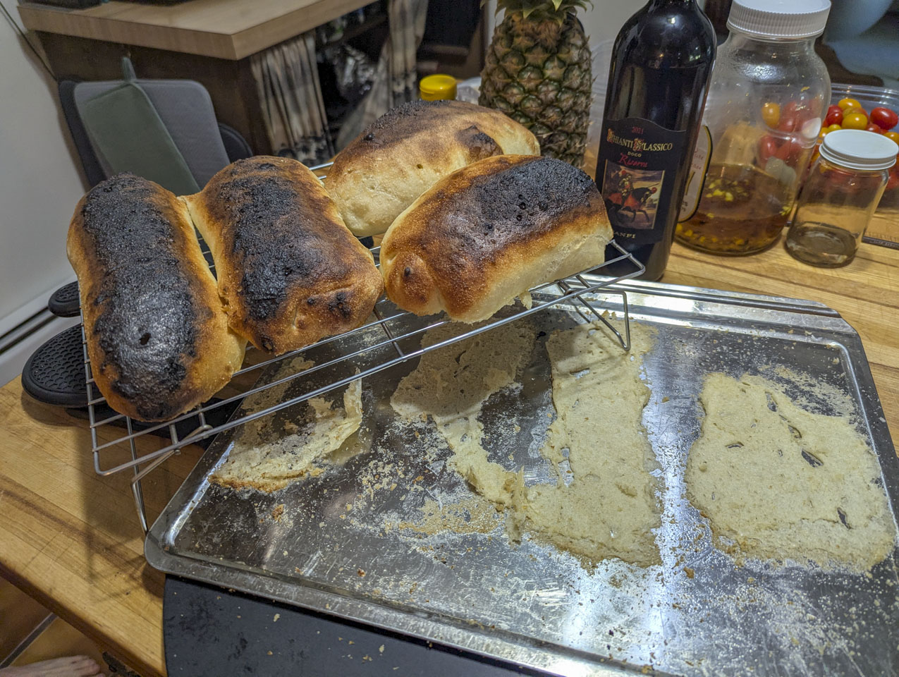 Large rolls with burnt tops and a tray with bits of bread sticking to it.