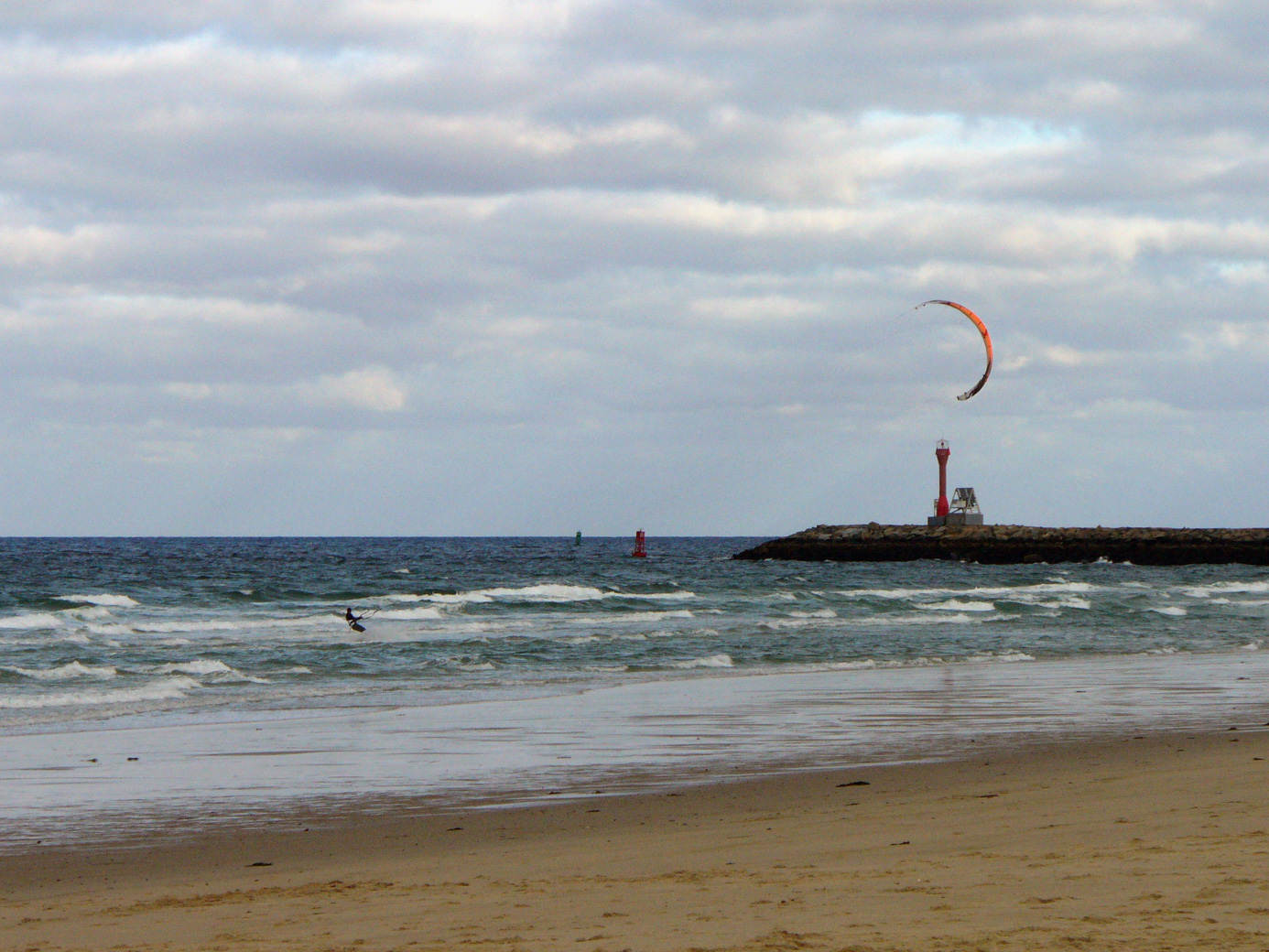 Man in wetsuit windsurfing at Scusset Beach with the breakwater to the left in the photo